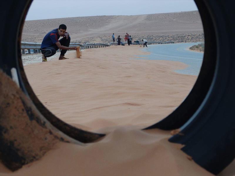 بالصور: مبادرة شبابية ﻹزالة الرمال بطريق نالوت - غريان