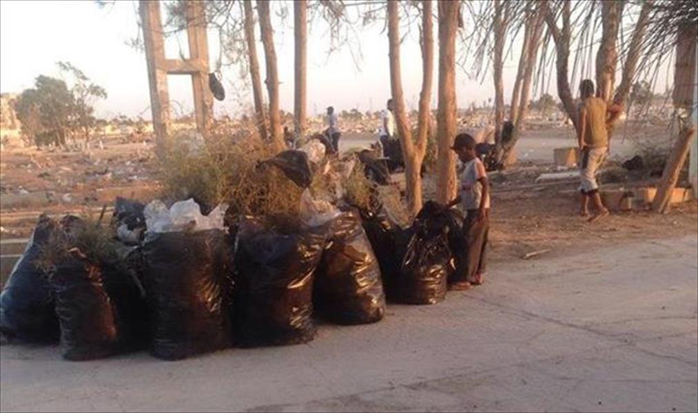 بالصور: شباب يتطوعون لتنظيف مقبرة الهواري في بنغازي