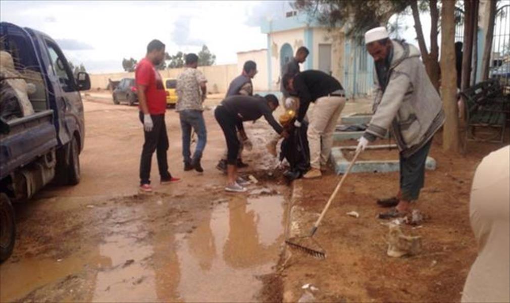 بالصور: شباب يتطوعون لتنظيف مقبرة الهواري في بنغازي