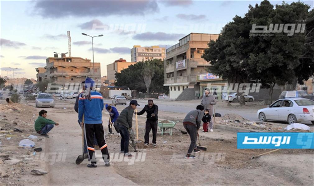 بالصور: متطوعون شباب يرمّمون طريق حي أمريرة في طبرق