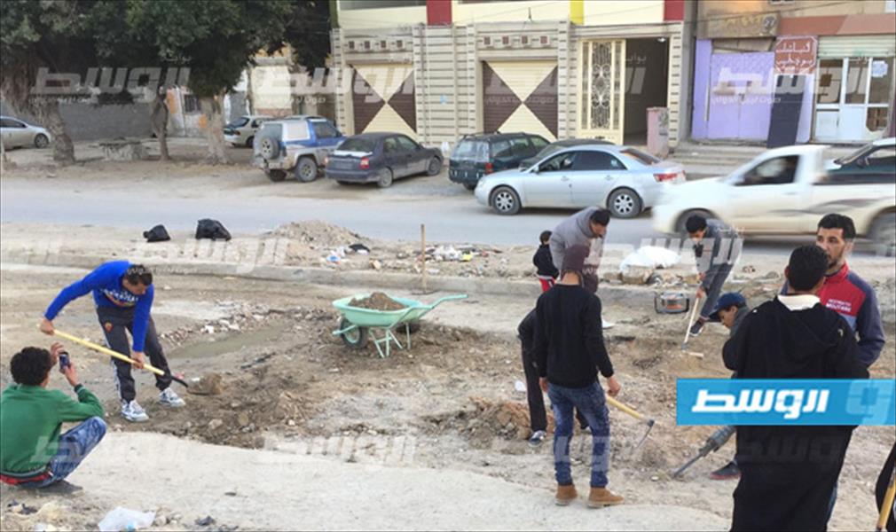 بالصور: متطوعون شباب يرمّمون طريق حي أمريرة في طبرق