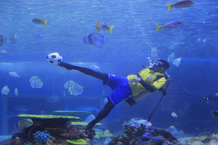 بالصور: غطاس يلعب كرة القدم تحت الماء