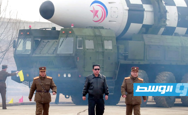 الزعيم الكوري الشمالي مرتديّاً سترته الجلدية السوداء المعتادة، يمشي على مدرج المطار أمام صاروخ ضخم. (وكالة أنباء كوريا الشمالية)
