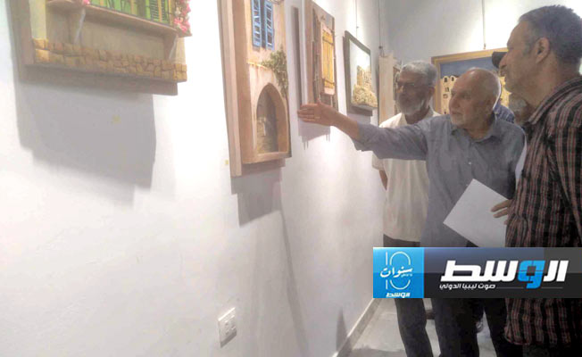 الفنان التشيكلي محمد التومي يتحدث عن أحد أعماله في المعرض. (بوابة الوسط)