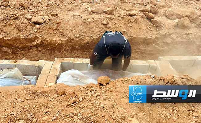 أفراد الهلال الأحمر خلال دفنهم جثة في مقبرة الهواري في بنغازي، 4 يونيو 2024. (صفحة فرع الجمعية في بنغازي على فيسبوك)