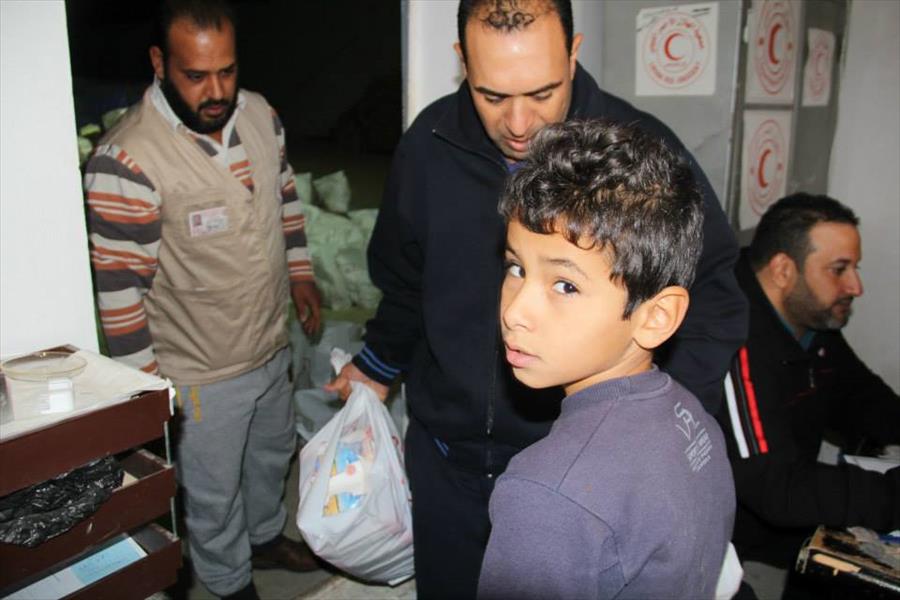 الصليب الأحمر يوزع مساعدات إنسانية على سكان حي قصر الضيافة بسرت