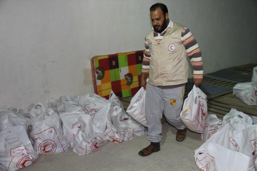 الصليب الأحمر يوزع مساعدات إنسانية على سكان حي قصر الضيافة بسرت