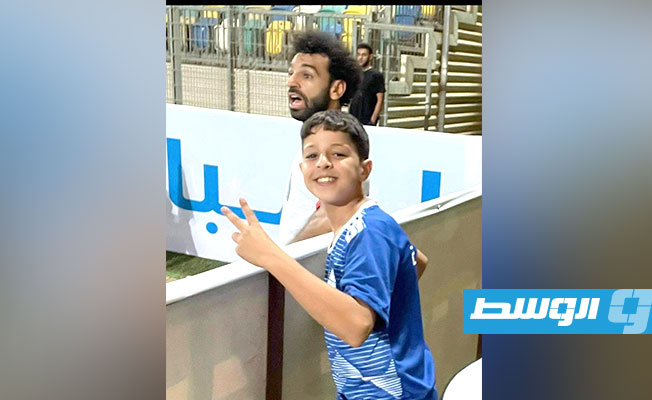 طفل ليبي يلتقط صورة تذكرية مع محمد صلاح بطريقة غريبة في مباراة مصر وليبيا بتصفيات كأس العالم. (الإنترنت)