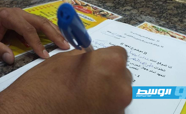 صاحب مطعم يوقع تعهدا خلال حملة على مطاعم مدينة بنغازي. (وال)