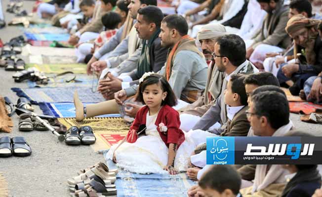 أطفال في ملابس العيد ينتظرون بداية الصلاة في صنعاء (إ.ب.أ)