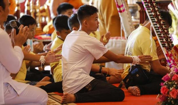 الفتيان التايلانديون يزورون معبدًا بوذيًا