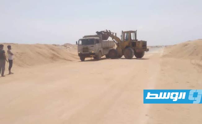 إزالة الكثبان الرملية التي تغطي طريق طبرق – أجدابيا الصحراوي. (الإنترنت)