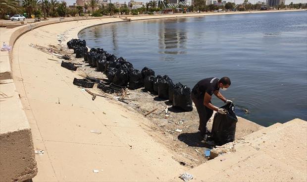 بالصور: مواطن وزوجته من بنغازي يقومان بتنظيف «كورنيش الجنينه»