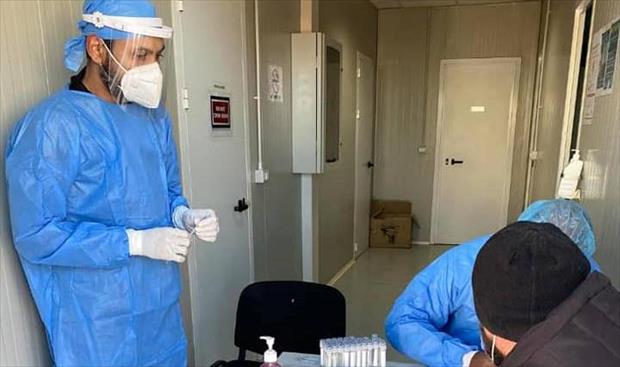 عنصران طبيان تابعان لفريق الرصد والاستجابة غدامس خلال سحب عينة للكشف عن فيروس «كورونا» من أحد العاملين بحقل الوفاء النفطي، 16 يناير 2021. (صفحة الفريق بموقع فيسبوك)