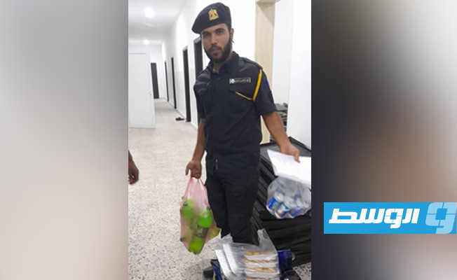 أحد عناصر الحرس البلدي في جولة تفتيشية في محل مواد غذائيى بمدينة سرت. (جهاز الحرس البلدي)
