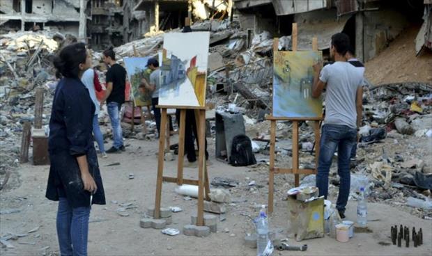 رسامون سوريون يفترشون الركام بمخيم اليرموك في دمشق