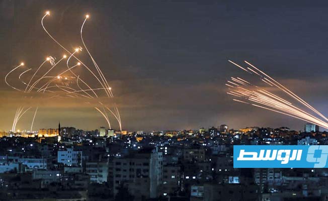 صواريخ أُطلقت من غزة باتجاه إسرائيل، وفي المقابل طلقات النظام الإسرائيلي المضاد للصواريخ. (فرانس برس)
