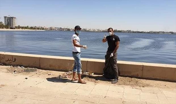 بالصور: مواطن وزوجته من بنغازي يقومان بتنظيف «كورنيش الجنينه»