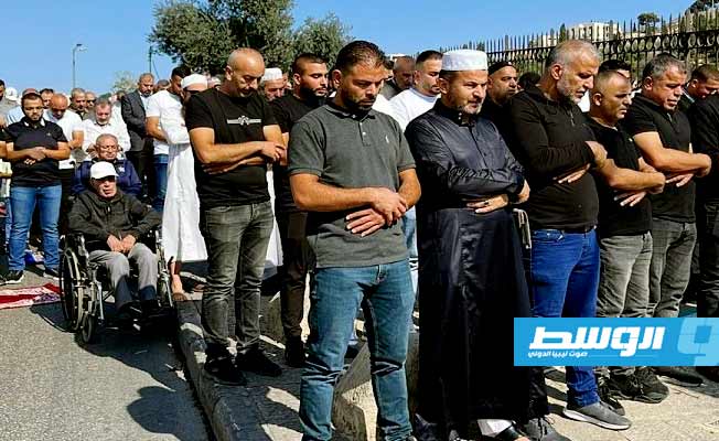 فلسطينيون يؤدون صلاة الجمعة قرب البلدة القديمة بعد منعهم من الوصول للمسجد الأقصى. (وفا)