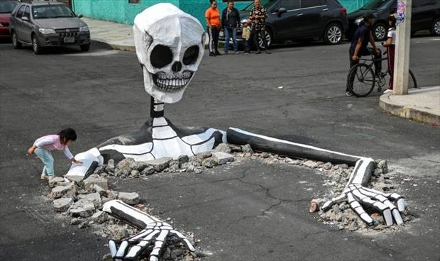 هياكل عظمية عملاقة في شوارع العاصمة المكسيكية استعدادا للاحتفال بيوم الموتى