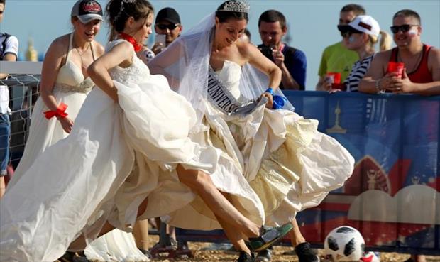 روسيات يلعبن كرة القدم بأثواب زفاف