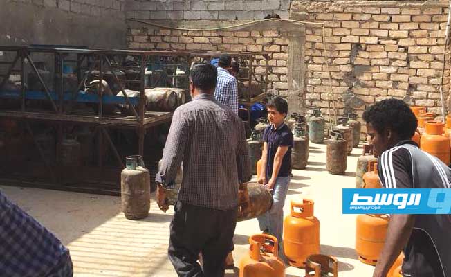 عمليات توزيع اسطوانات الغاز في أحد المستودعات. (صفحة لجنة أزمة الوقود والغاز)