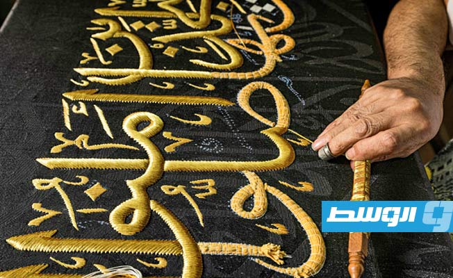حرفي يطرز بخيوط من ذهب آية قرآنية في بالقاهرة الإسلامية، 15 يونيو 2022 (أ ف ب)