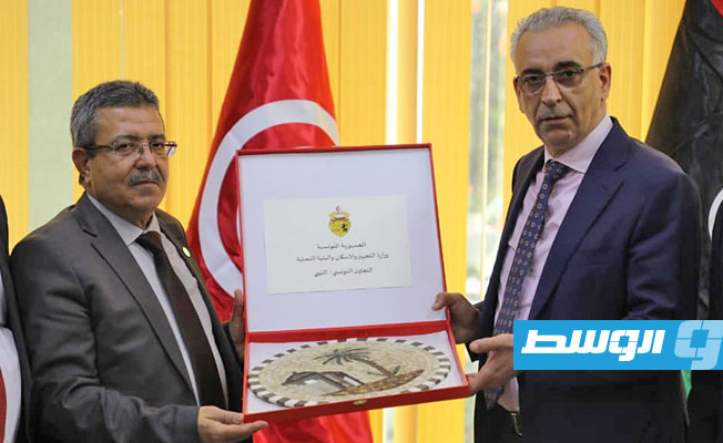 وزير الإسكان بحكومة الوحدة الوطنية الموقتة أبوبكر الغاوي يمنح هدية تذكارية إلى وزير التجهيز والإسكان التونسي كمال الدوخ، 24 مايو 2021. (وزارة الإسكان)
