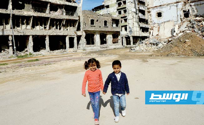 طفلان أمام مبان مدمرة نتيجة حرب طرابلس. (الإنترنت)