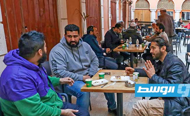 مجموعة من الرجال يشربون القهوة على شرفة في طرابلس، 16 مارس 2023 (أ ف ب)