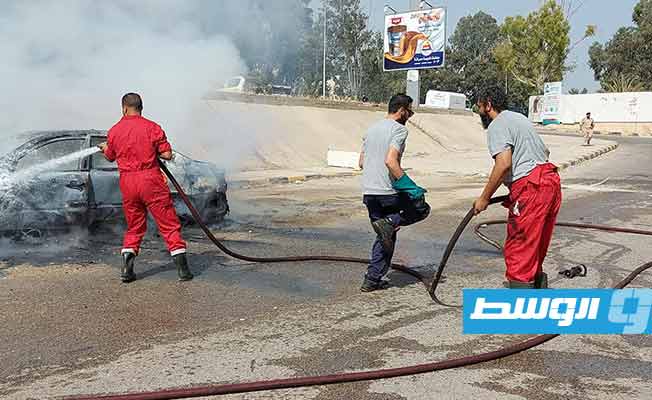 رجال هيئة السلامة الوطنية والأمن أثناء إطفاء حريق سيارة في طرابلس، 2 سبتمبر 2021. (مديرية الأمن)