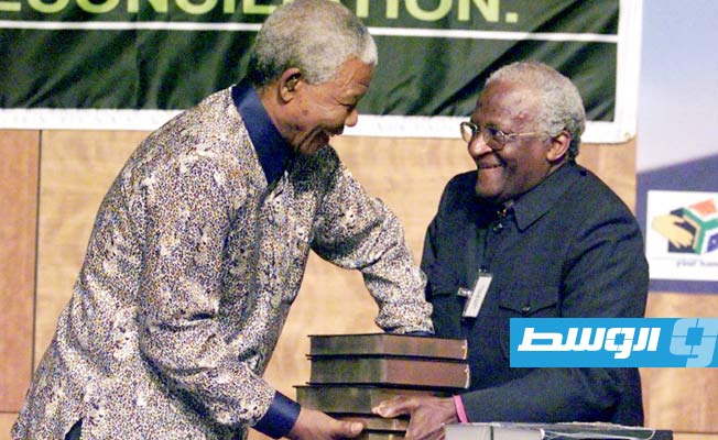 رئيس لجنة الحقيقة والمصالحة «TRC» القس ديزموند توتو يسلم تقرير اللجنة إلى رئيس جنوب إفريقيا نيلسون مانديلا في بريتوريا. 29 أكتوبر 1998.(رويترز).