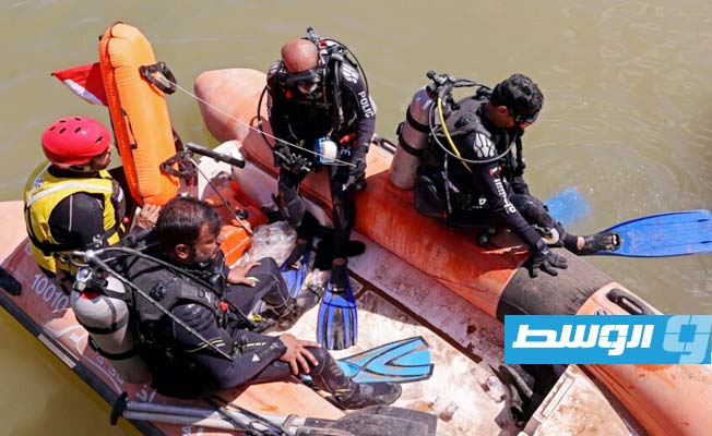 عناصر إغاثة من فريق إماراتي يغطسون في البحر قبالة ميناء درنة في شرق ليبيا، 18 سبتمبر 2023 (أ ف ب)
