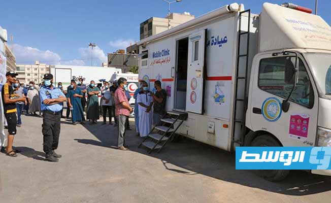 مواطنون يتوافدون على عيادة متنقلة بمدينة الخمس للتطعيم ضد فيروس كورونا، الأحد 18 يوليو 2021. (المركز الوطني لمكافحة الأمراض)