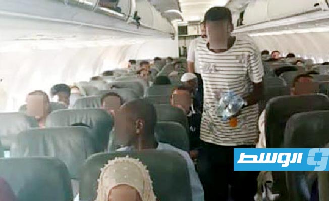 مواطنون ليبيون في طائرة العودة من السودان إلى مطار بنينا، 13 مايو 2023. (وزارة الخارجية)