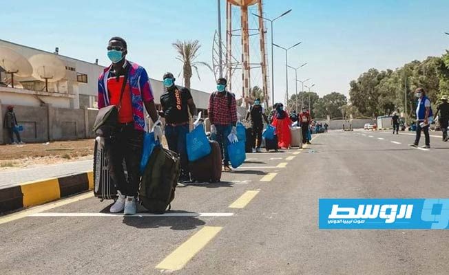 مهاجرون يستعدون للسفر من مطار معيتيقة في طرابلس. (وزارة الداخلية)