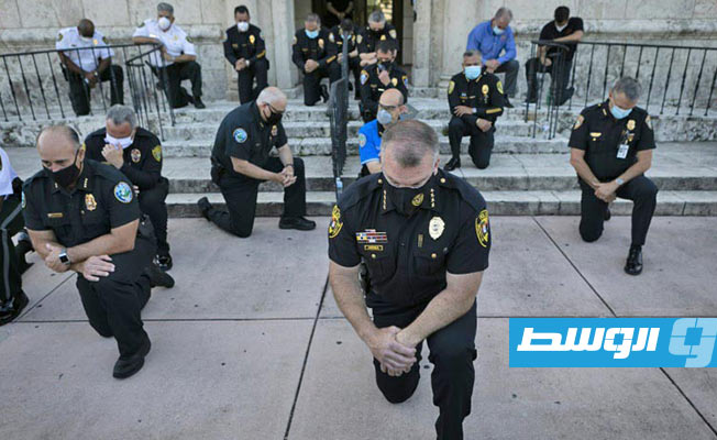 شرطيون أميركيون يركعون على ركبة واحدة دعما للاحتجاجات ضد العنصرية (فيديو)