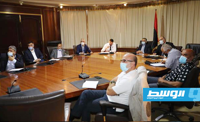 وزير الاقتصاد والتجارة بحكومة الوحدة الوطنية الموقتة محمد الحويج يتابع عرضا مرئيا خلال لقاء مع عدد من رجال الأعمال، 28 يوليو 2021. (وزارة الاقتصاد)