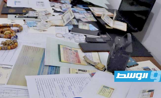 جوازات سفر ومُستندات مزورة بعد العثور عليها بحوزة المتهم الغاني، 16 أبريل 2023. (مديرية أمن بنغازي)