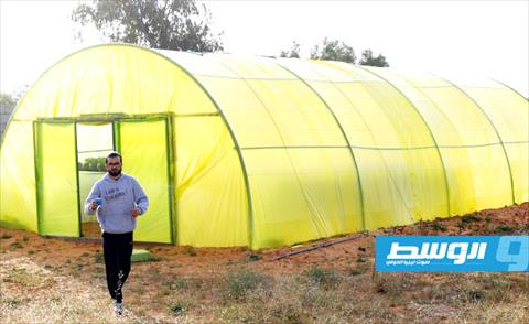 سراج بشيه خارج الخيمة الزراعية لمشروع «الجنة الخضراء» في القويعة شرق طرابلس, 5 مارس 2021 (أ ف ب)