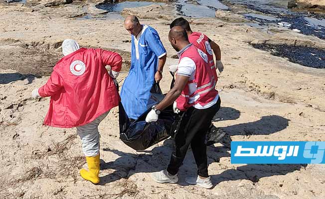 متطوعو الهلال الأحمر أثناء انتشال الجثامين من وبجوار القارب على شاطئ صبراتة، الجمعة 7 أكتوبر 2022. (الهلال الأحمر)