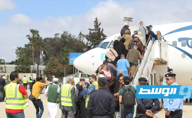 الركاب لدى استقلالهم أول رحلة مسيرة من مطار بنينا إلى مطار القاهرة الدولي منذ 7 سنوات.