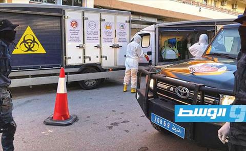 الأمن يرافق رجال شركة النظافة المسؤولة عن تعقيم مستشفى القلب تاجوراء، 31 مارس 2020، (داخلية الوفاق)
