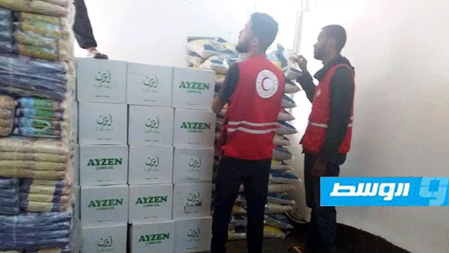 «الهلال الأحمر» توزع مساعدات غذائية للأسر النازحة إلى ترهونة من جنوب طرابلس