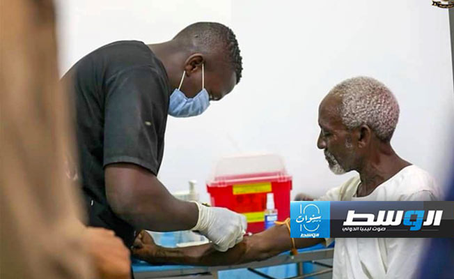 مهاجر يتلقى الرعاية الصحية بعد تحريره من قبضة مهربين في الكفرة وتازربو، 8 يونيو 2024. (مكتب النائب العام)