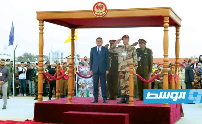 الدبيبة والحداد على منصة الشرف أثناء حضورهما الحفل بالكلية العسكرية في طرابلس. (وزارة الدفاع)
