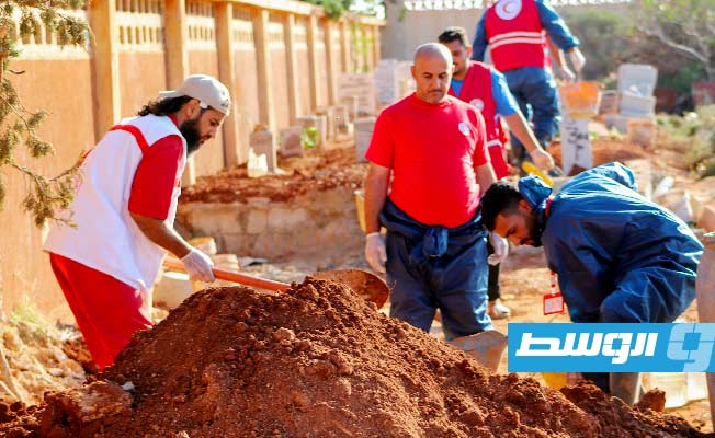 متطوعو الهلال الأحمر في درنة خلال دفن رفاة 49 شخصًا كان قد جرى استخراجها من مقبرة الصحابة أثناء الفيضانات. (جمعية الهلال الأحمر في درنة)