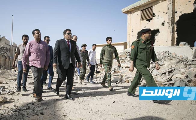رئيس المجلس الرئاسي، محمد المنفي، والوفد المرافق له في زيارة للمناطق المدمرة بمدينة سرت. (الإنترنت)