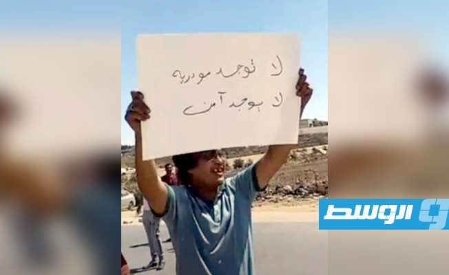 شاب يرفع لافتة في القبة تندد بالوضع الأمني. الثلاثاء 25 أغسطس 2020. (الإنترنت)
