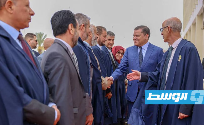 الدبيبة يصافح أحد الحضور في الجلسة الافتتاحية للمؤتمر العلمي للموارد المائية والأمن المائي في ليبيا بمدرج رشيد كعبار بجامعة طرابلس، 15 مايو 2023. (حكومة الوحدة الوطنية)